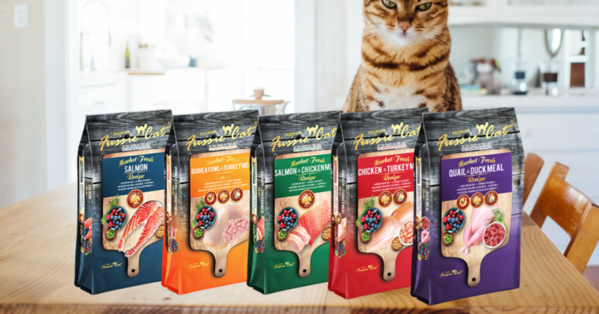 five bags of cat food on wood counter with cat behind them
