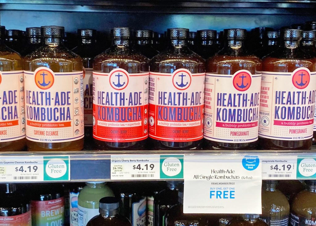 store shelf filled with glass bottles of Health-Ade Kombucha drinks