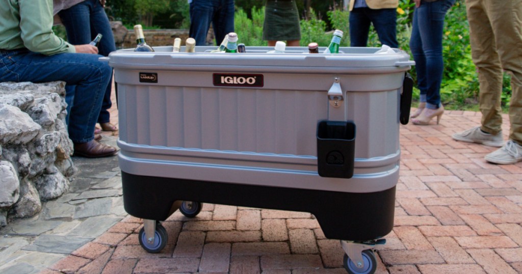 Igloo Cooler Bar Cooler on wheels outside on a patio with people standing behind it