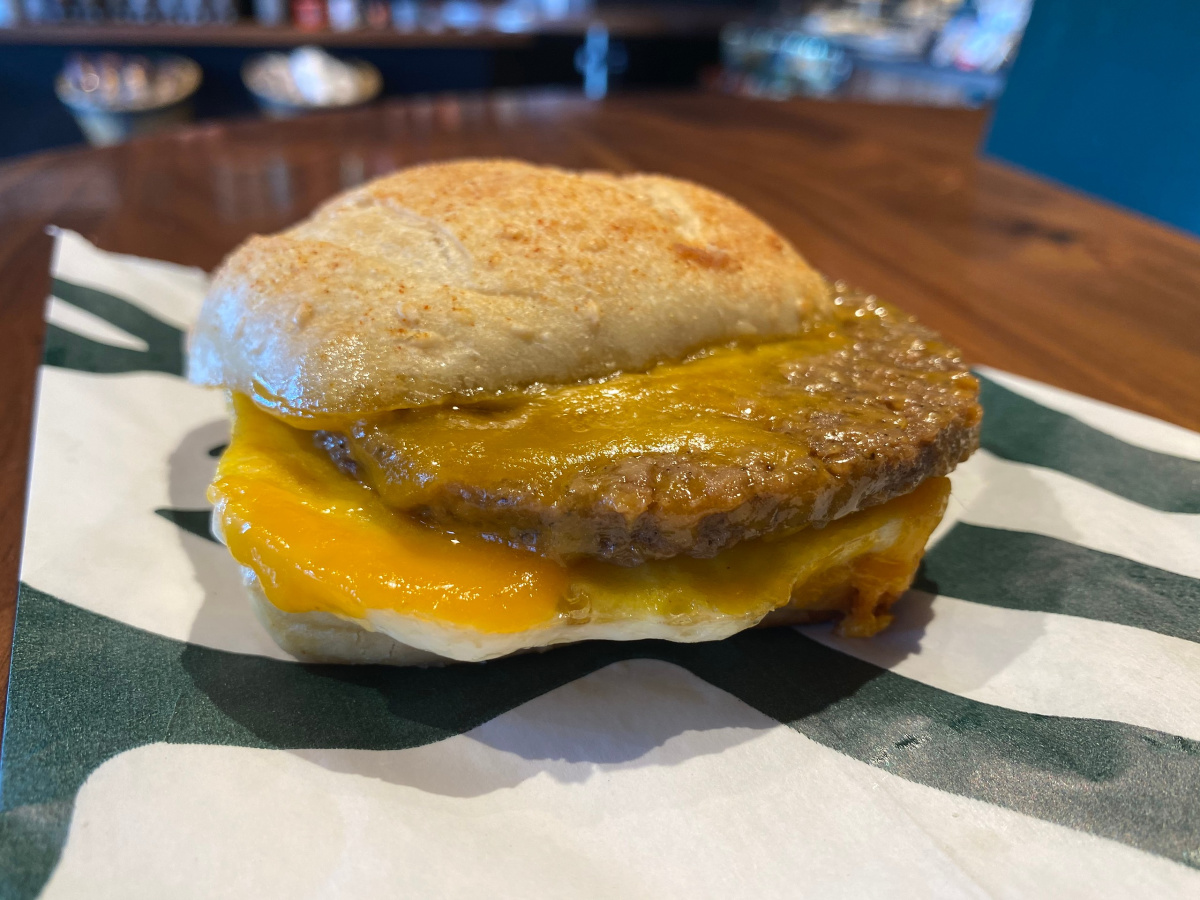 sausage egg and cheese sandwich laying on Starbucks bag