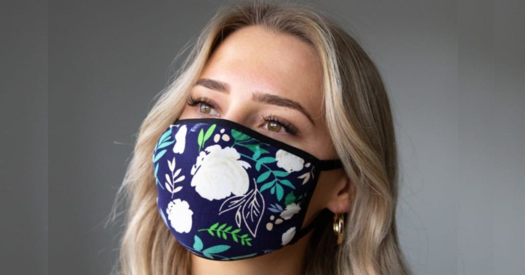 woman with blond hair wearing navy and flower printed face maks