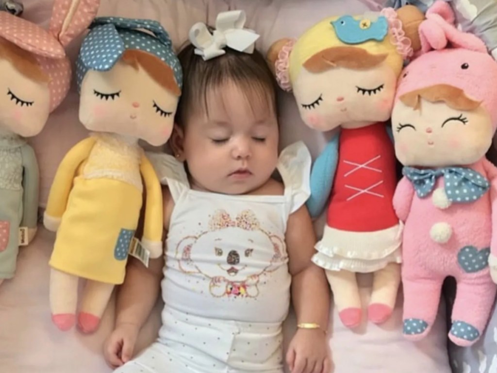 baby girl sleeping with stuffed dolls