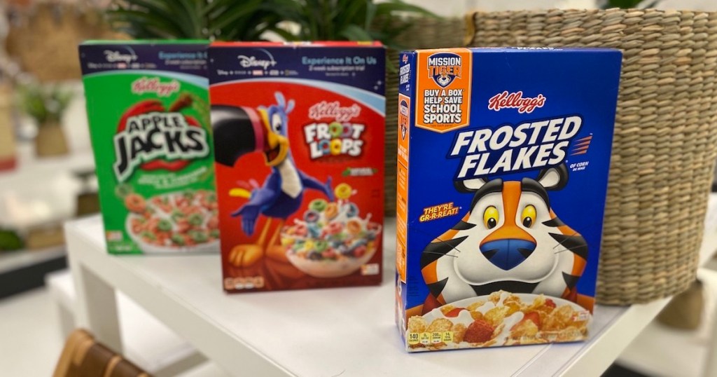 kellogg's frosted flakes, froot loops, and apple jacks on table with plant in the background