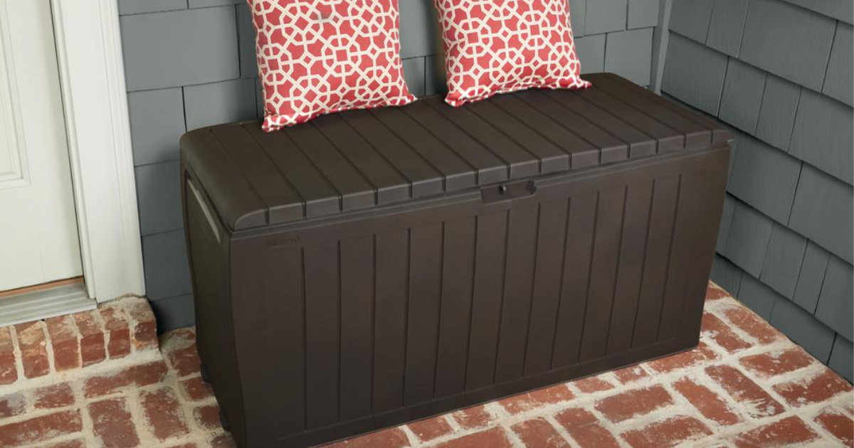 brown deck box on brick patio with pillows on deck box