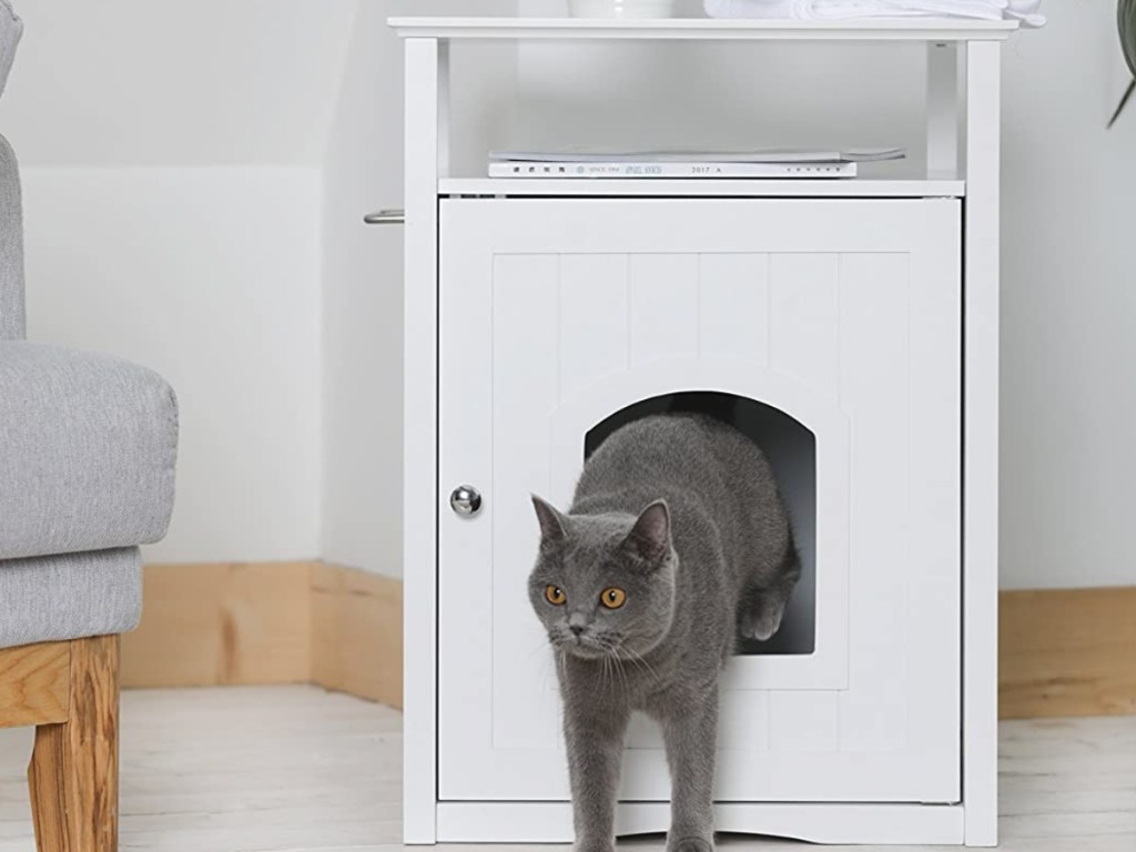 gray cat jumping out of white litter box table cover