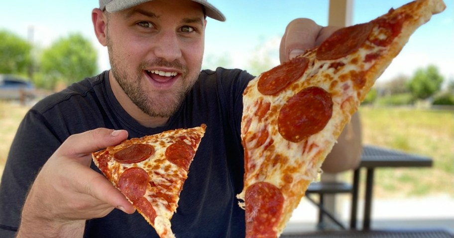 man holding Little Caesars Pizza slices