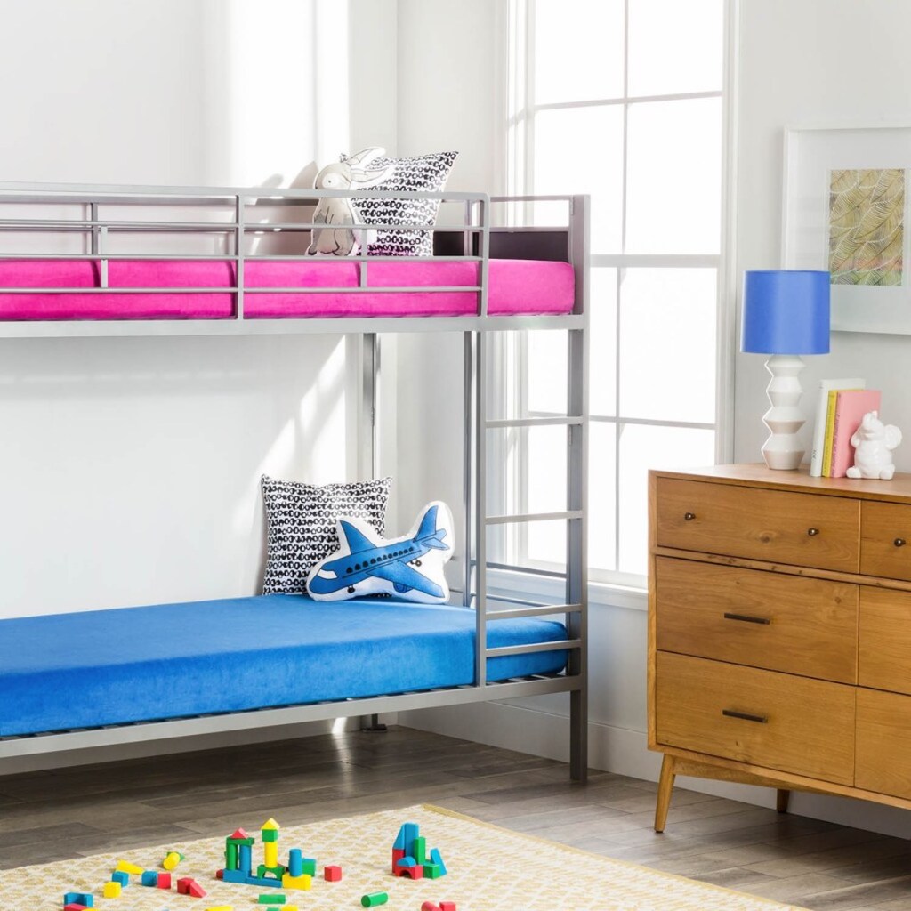 kids bedroom with bunkbeds. blue waterproof mattress on bottom and hot pink waterproof mattress on top with toys on the floor