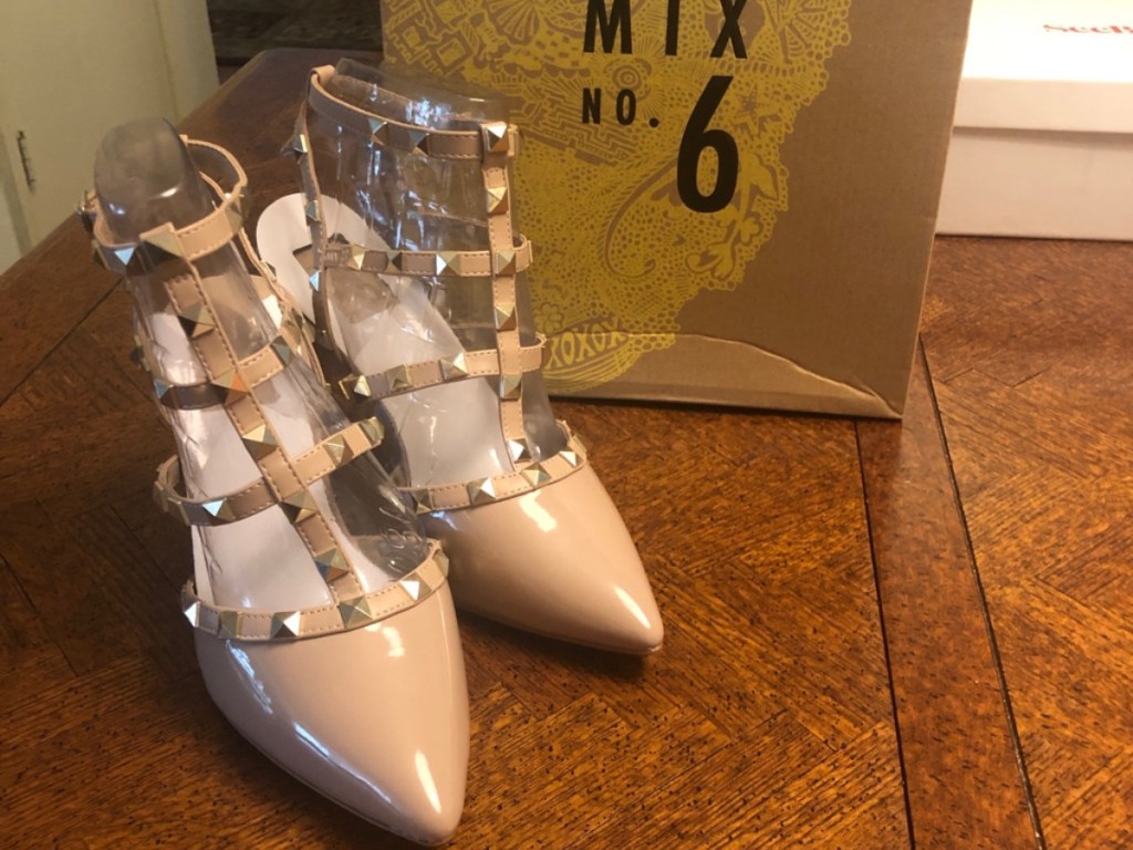beige heels with studded clear straps on wood table