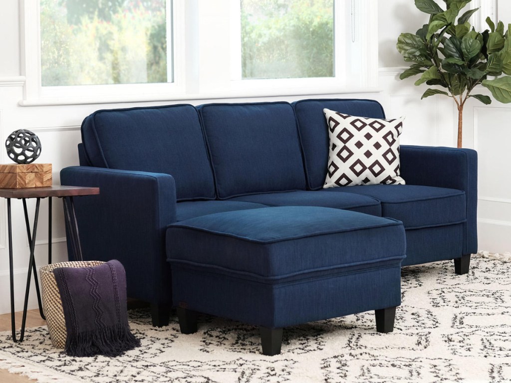 Navy Blue Sofa and Ottoman Set in a small room next to a table