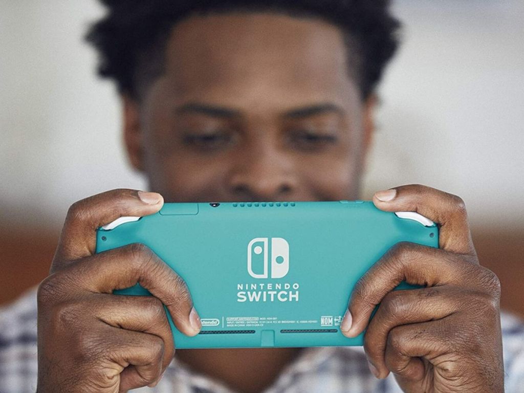 man playing nintendo switch lite game