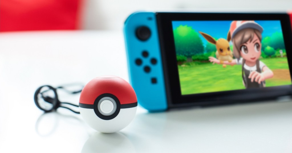 Nintendo Switch gaming console and Poke Ball controller on table