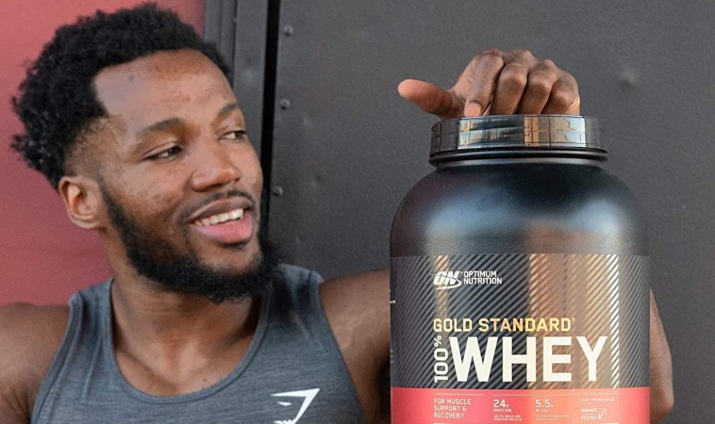 man looking at canister of protein powder