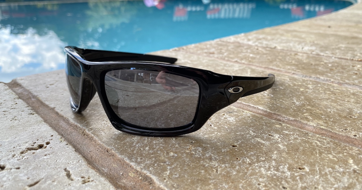 pair of Oakley Men's Valve Sunglasses sitting on pool side deck area