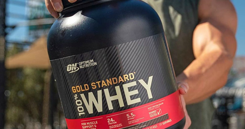 man holding a canister of Optimum Nutrition whey