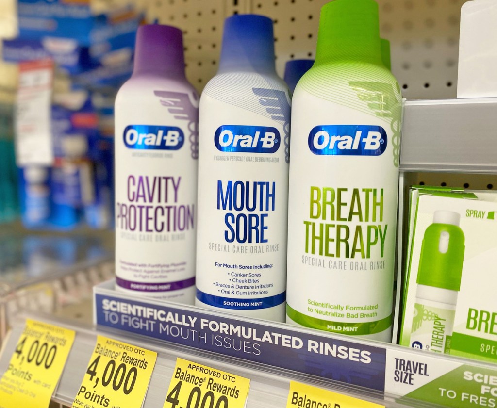 thee cans of oral-b specialty mouth washes on a store shelf