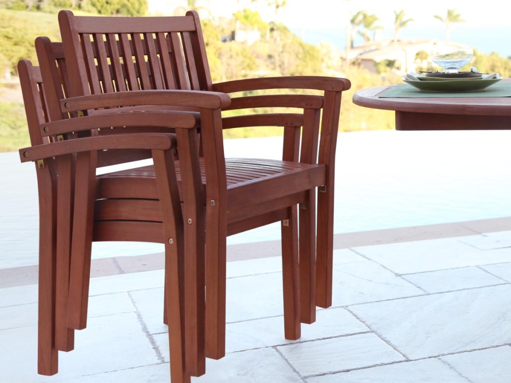 multiple outdoor patio chairs stacked together next to a table