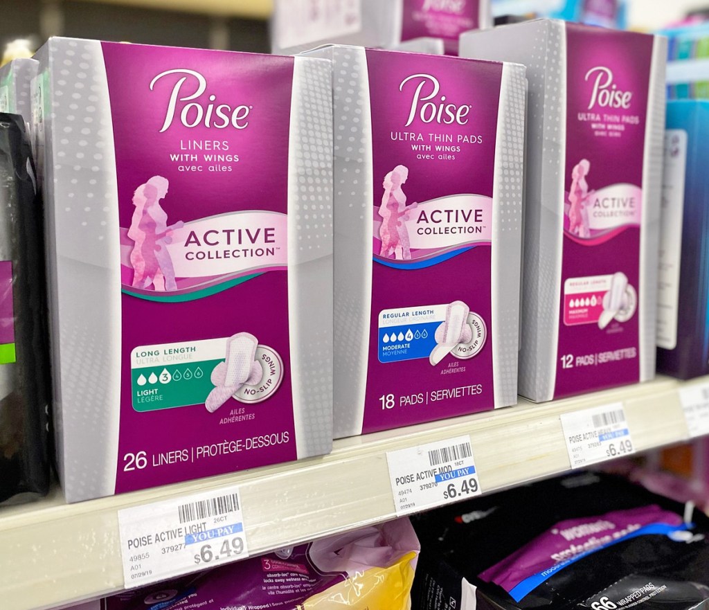 three pink and grey boxes of poise active collection pads and liners on store shelf