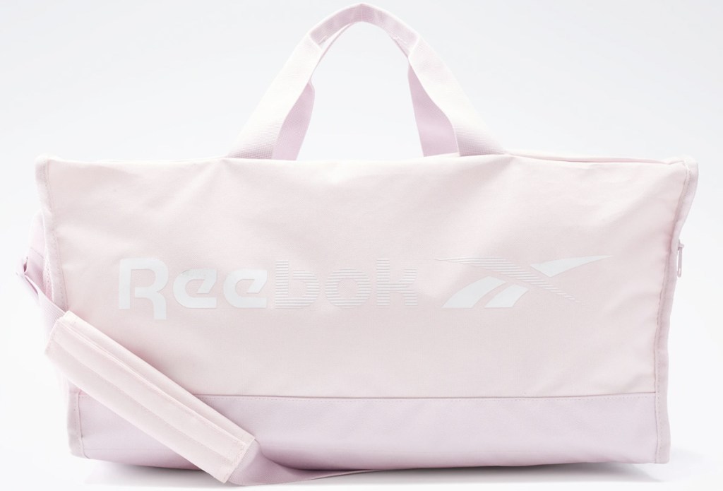 light pink duffel bag that says reebok on the side