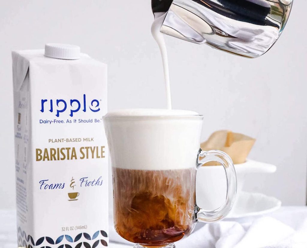 person pouring milk into coffee
