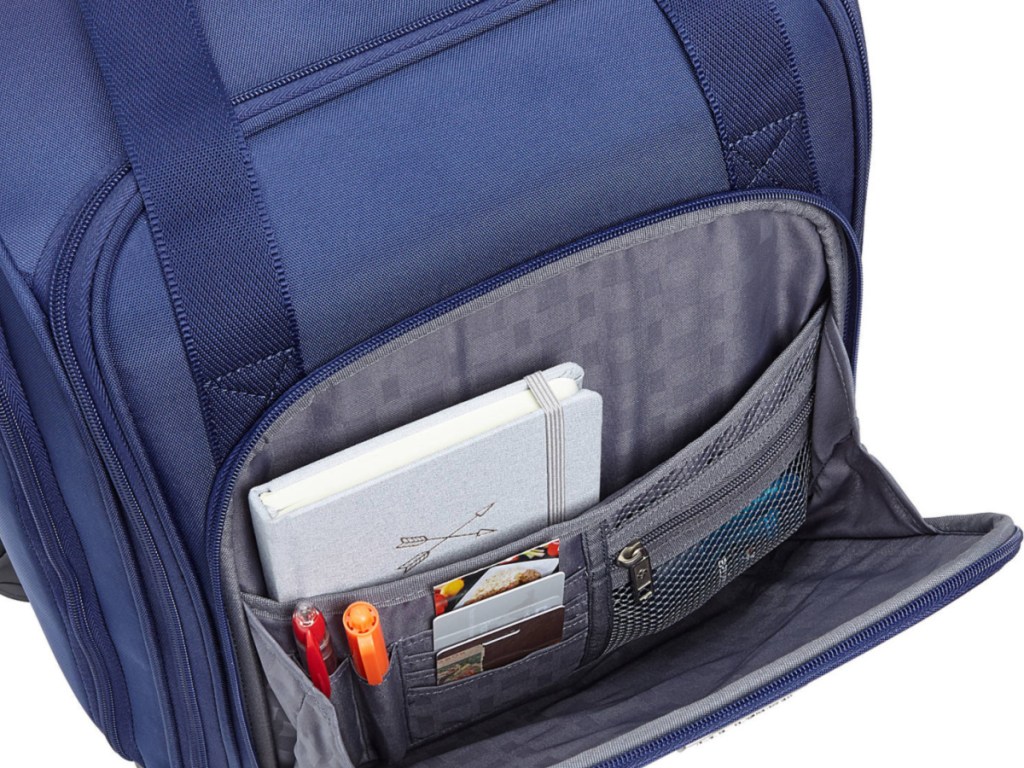 blue unzipped carry-on luggage opened with pens and paper