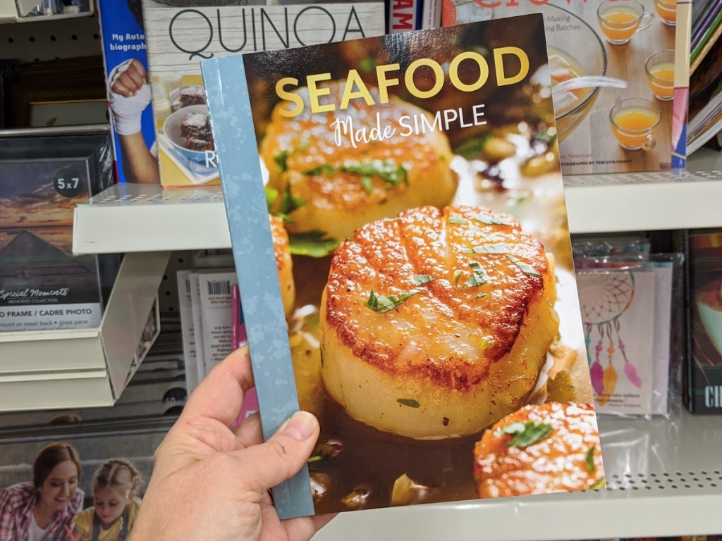 hand holding a Seafood cookbook