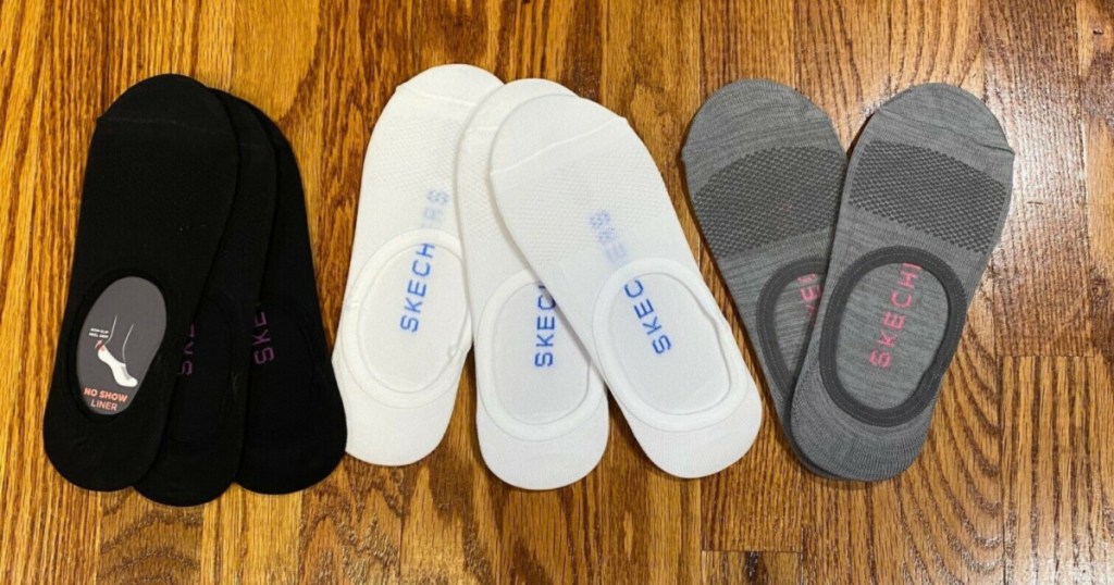 women's black, white, and grey no show liner socks on wood surface