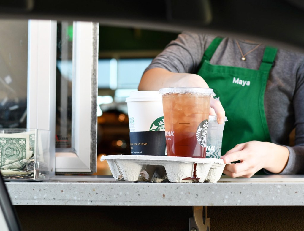 view of drive-thru window at starbucks with barista handing out drinks