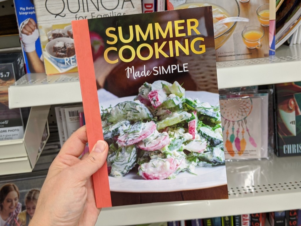 hand holding a Summer Cooking Made Simple cookbook