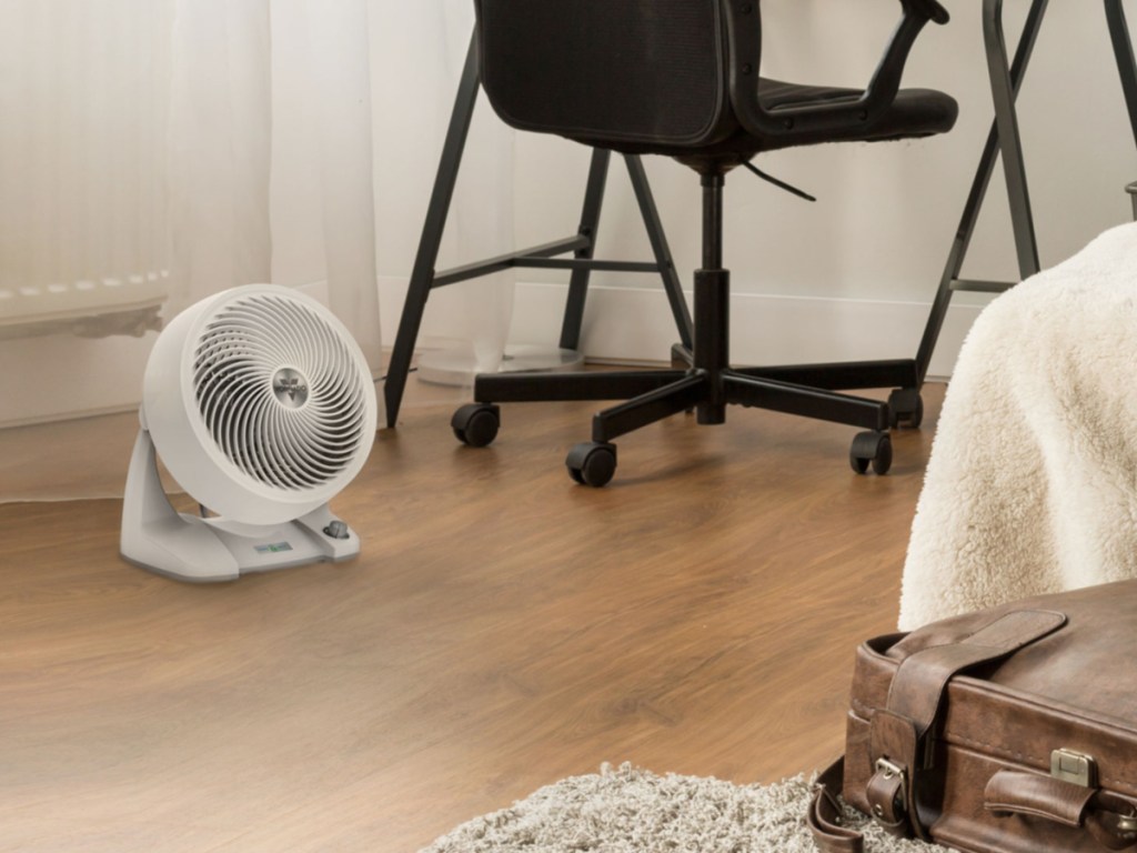 small white fan on floor near black office chair