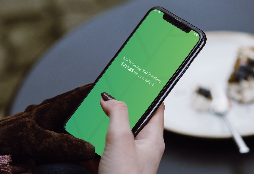 hand holding phone with green future savings on screen