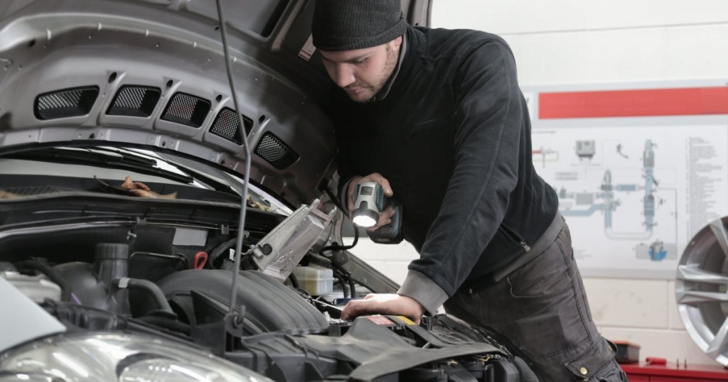 auto mechanic under the hood of a car