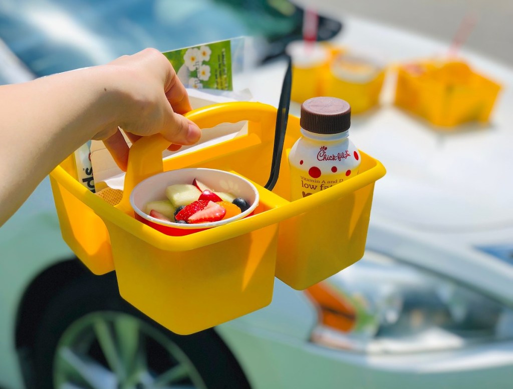 hand holding a yellow caddy with kids meal inside