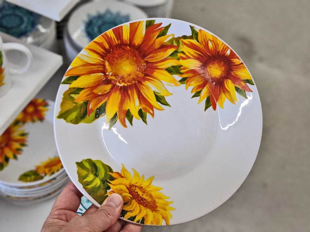 hand holding up a sunflower dinner plate