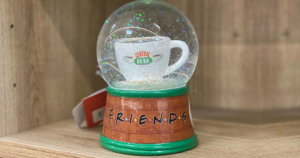 snow globe on shelf with coffee cup in middle