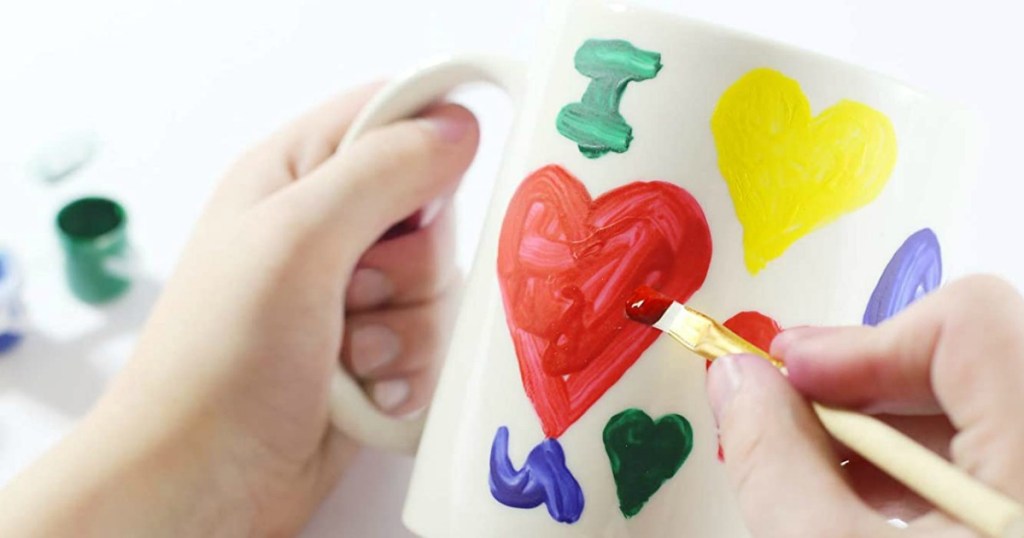 person painting a mug