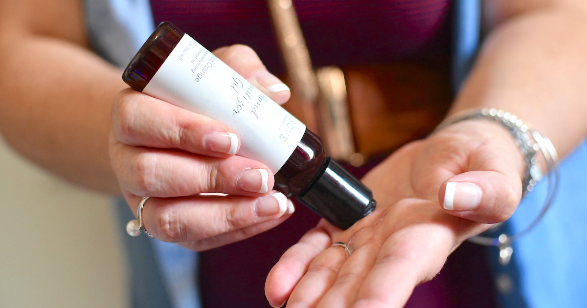 hand squeezing bottle of hand sanitizer onto other hand