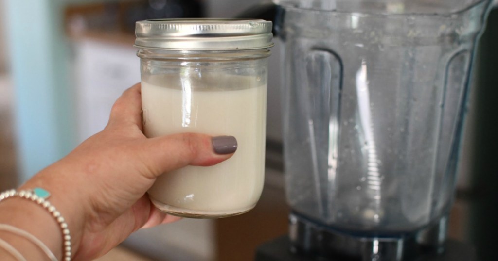 holding jar of oat milk