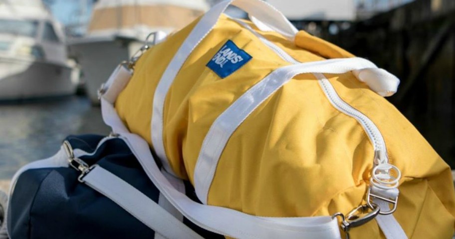 yellow duffle bag sitting on top of blue one near pier