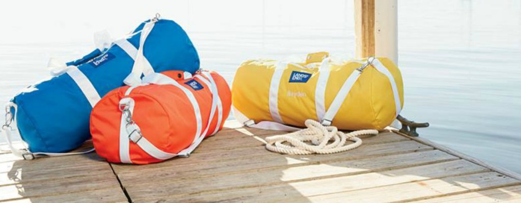 three colorful duffle bags sitting on pier