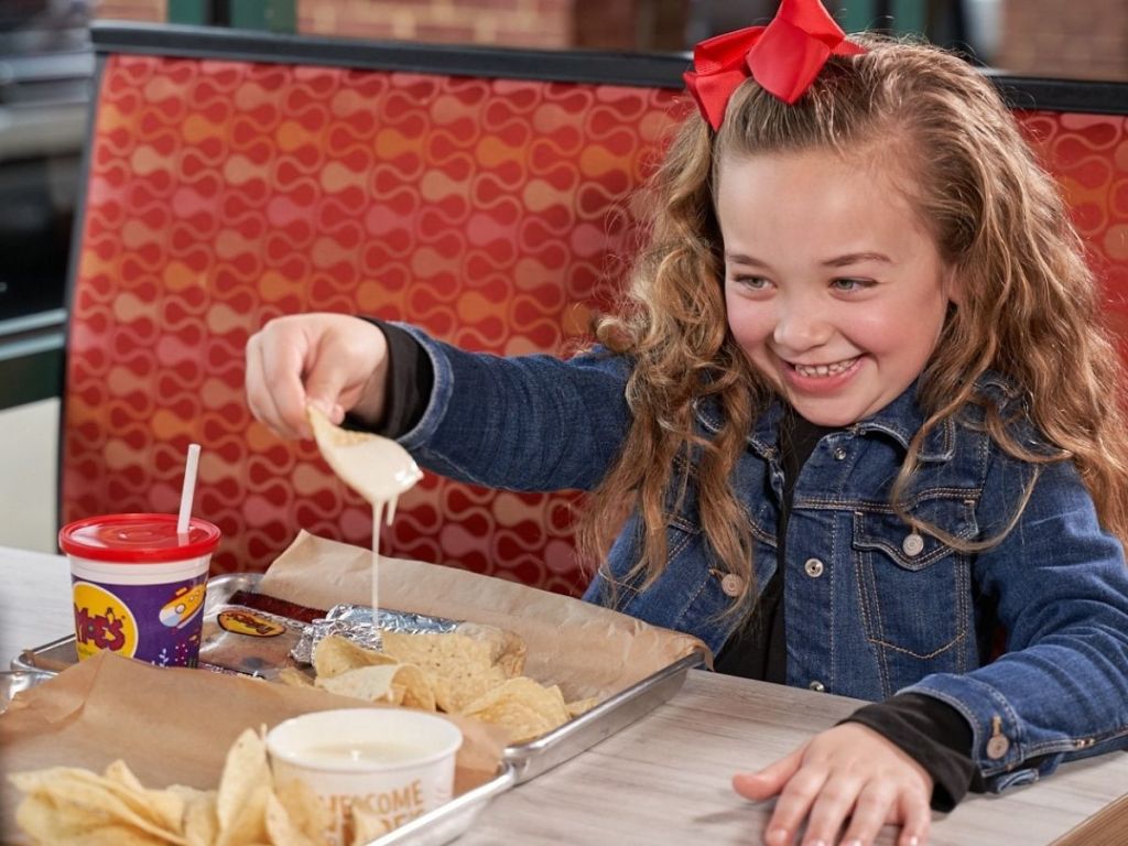 little girl eating moe's nachos