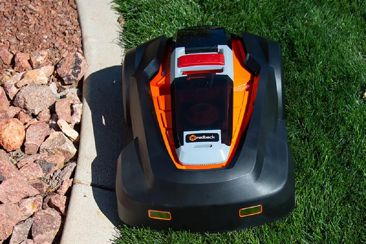 robot lawn mower on grass next to rocks