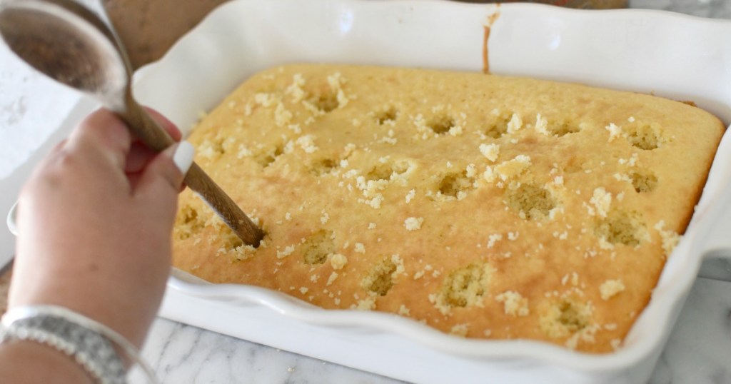 poking a cake with wooden spoon