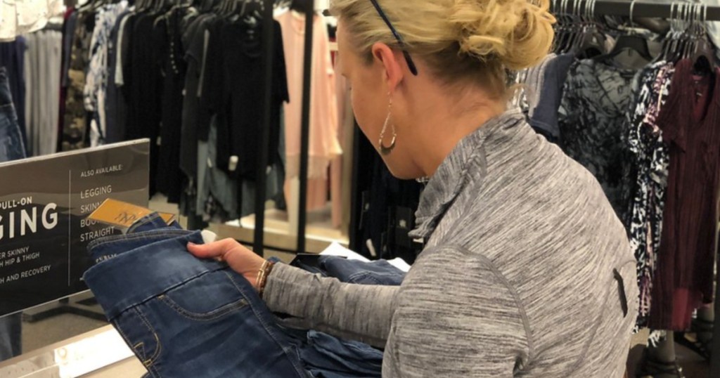 woman looking at jeans in store