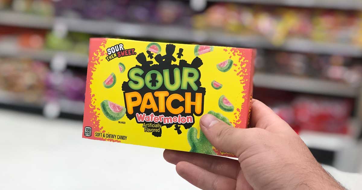 hand holding theater box of sour patch kids candy