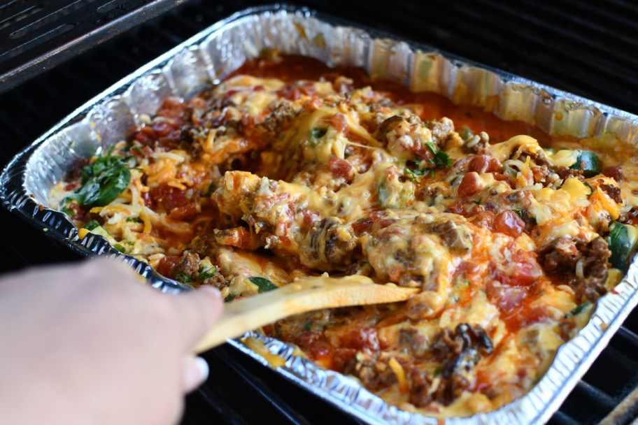 stirring queso on grill