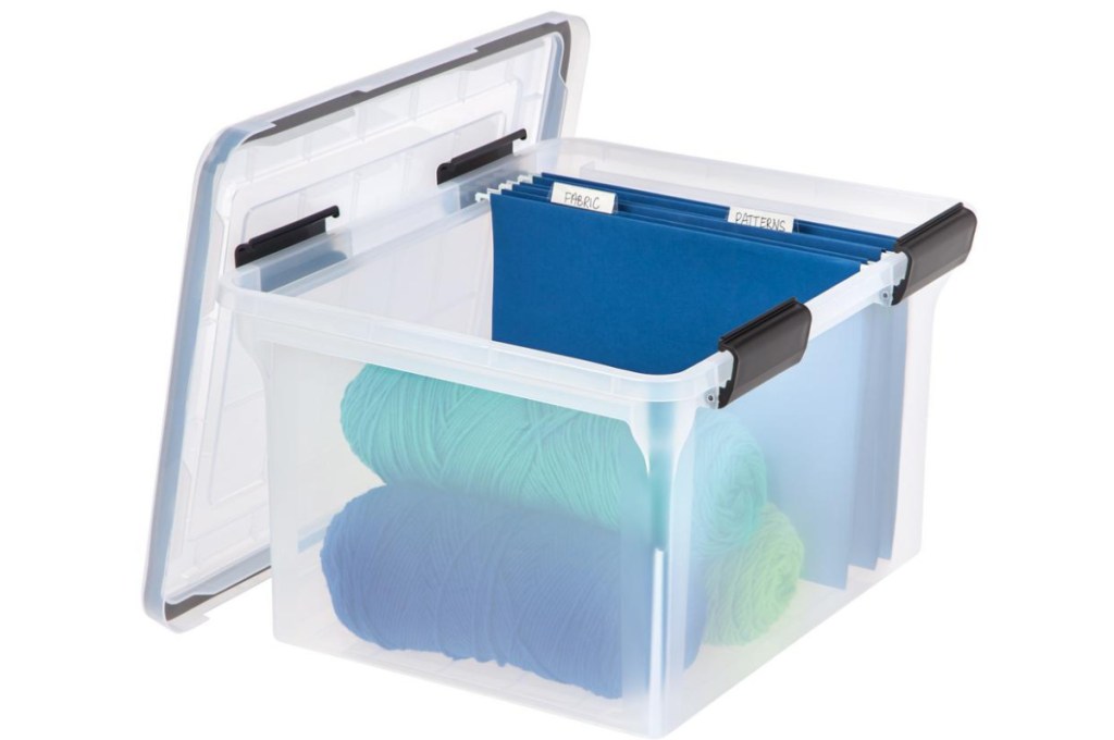 blue folders and yarn in clear storage bin