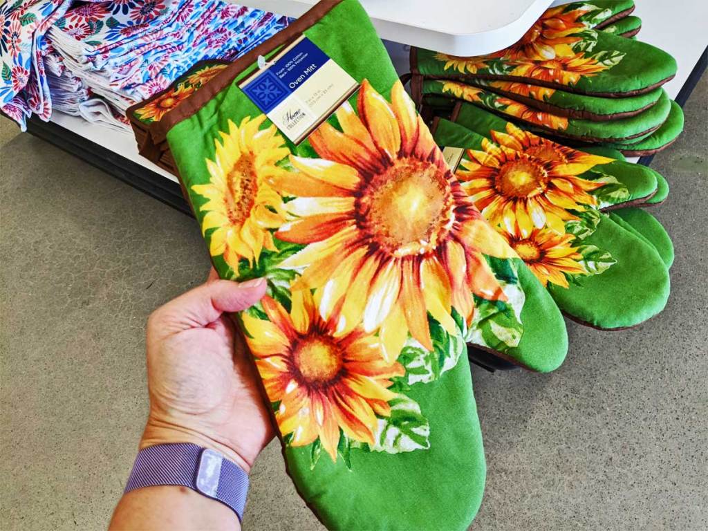 hand holding a sunflower oven mitt up in a store