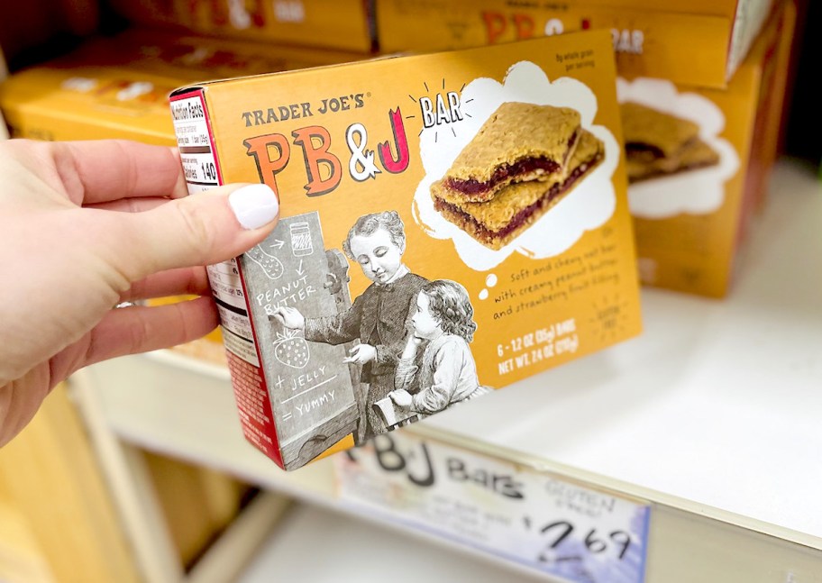 hand holding a peanut butter jelly bar box on trader joes store shelf - best Trader Joe's items