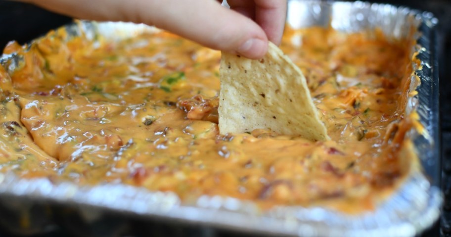 dipping chip into velveeta queso dip 