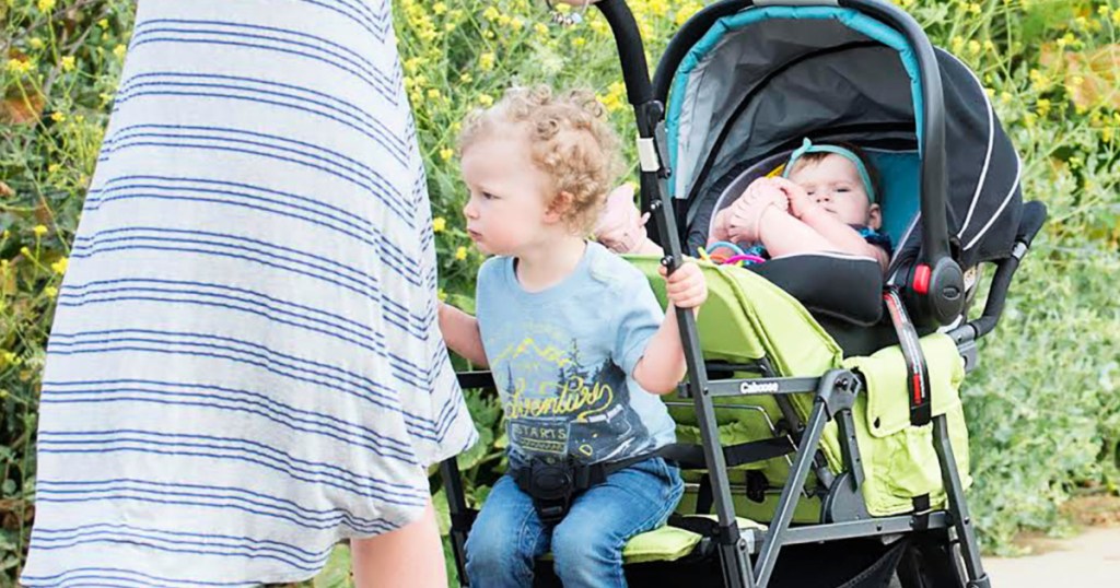 woman pushing children in a Joovy Caboose Stand-On Stroller in Appletree